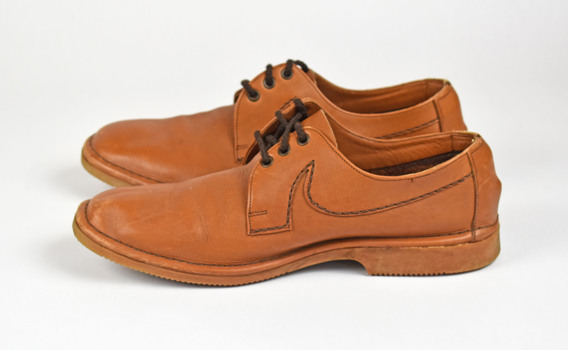 side view of two tan shoes with brown laces