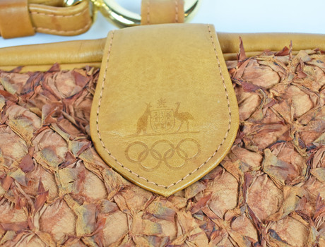 detail of bag showing imprint of kangaroo and emu coat of arms with olympic rings, surrounded by textured fabric