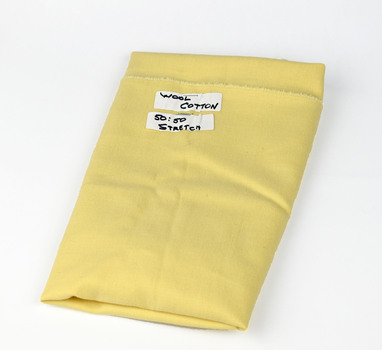 folded cream fabric with two white labels with black hand written text