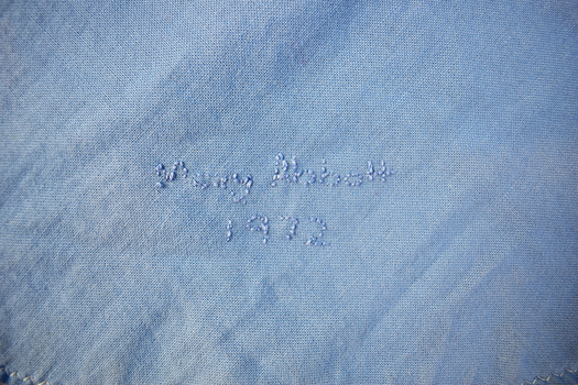 detail of quilt backing showing hand stitched name and date 