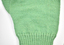 detail of green knitted glove showing fine stitching