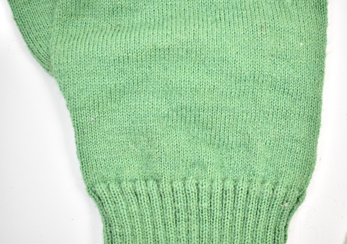 detail of green knitted glove showing fine stitching