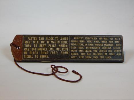 Wooden Block painted with instructions to attach line from shipwreck to shore. 



