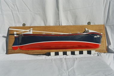 Half Model of Port Fairy Life Boat painted dark Blue and red as in 1930 decoration on wood panel. Covered with Blue plywood cover.