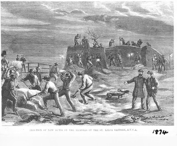 Two dozen men on a beach at night, digging sand with shovels, breaking rocks with picks and making wooden supports to create a wall that is in the background.