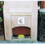 A fireplace with a yellow bowl in the hearth. On the front is a picture of a dog and a sign with the words 'Dogs Bar'. 