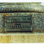 Metal plaque attached to base of granite pedestal. Raised letters on the plaque read 'This dining fountain is a gift to the public from Sali Cleve Esq April, 1911'