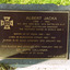 Rectangular metal plate inscribed with gold text and mounted on stone