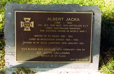 Rectangular metal plate inscribed with gold text and mounted on stone