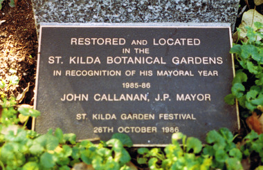 Rectangular metal plate inscribed with the words: Restored and located in the St Kilda Botanical Gardens in recognition of his mayoral year 1985-86. John Callanan, JP,  Mayor. St Kilda Garden Festival 26th October 1986