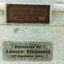 A rectangular bronze plaque is attached to a granite stone pedestal and displays, in raised letters, the words 'Captain Cook HMS Endeavour August 26th 1768'. Beneath it, the words 'Presented By Andrew Stenhouse 3rd December 1914' are inscribed into the stone.