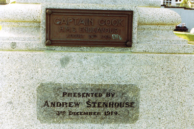 A rectangular bronze plaque is attached to a granite stone pedestal and displays, in raised letters, the words 'Captain Cook HMS Endeavour August 26th 1768'. Beneath it, the words 'Presented By Andrew Stenhouse 3rd December 1914' are inscribed into the stone.