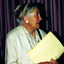 Profile of elderly woman in a light coloured jacket and holding a yellow folder