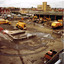 Garbage and water trucks in open yard.
