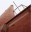 Part of a brick wall, chimney and metal structure.