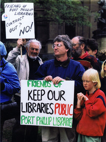 Two men in a crowd hold signs for Friends of Port Phillip Libraries. The messages are: "Contract out? No!" and "Keep Our Libraries Public"