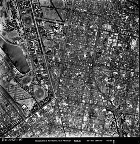 Rooftops, roads, trees and open spaces seen from the air directly above.