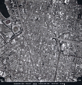 Rooftops, roads, trees and open spaces seen from the air directly above.