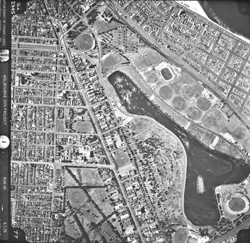Rooftops, roads, trees and open spaces seen from the air directly above