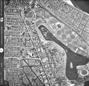 Rooftops, roads, trees and open spaces seen from the air directly above