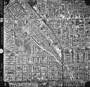 Rooftops, roads, trees and open spaces seen from the air directly above