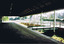 An empty, disused, station platform, covered by a wooden roof. 