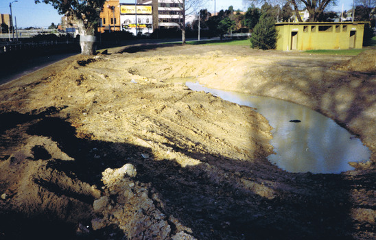 A muddy pond in cleared land
