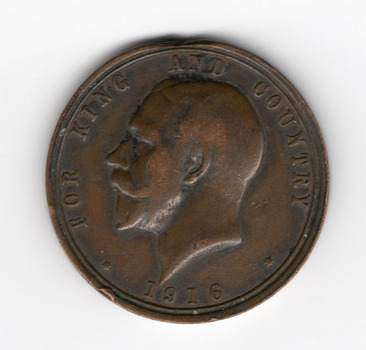 Circular brown medallion with words and numerals around the circumference For King and Country 1916. In the centre a man's head in profile facing left. 