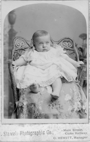 Photograph, Mr. Claude Raitt as a baby in a cane & seagrass chair. c1907