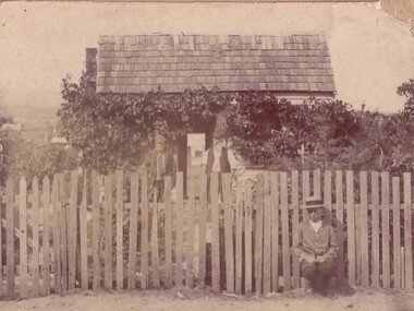 Photograph, 2 Gentlemen standing in front of weatherboard home and young boy seated against the picket fence -- Swalwell & Eastlake families
