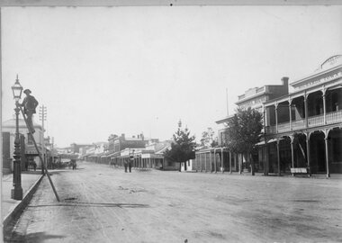 Photograph, Main Street Stawell from front of Town Hall looking East with Mr Richard Miller lighting the gas light on left of photo