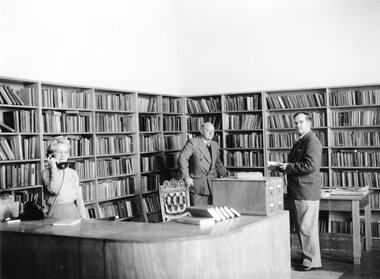 Photograph, Mechanics Institute Library interior with Miss Anne Carroll  -- Librarian & the man with the book is Mr Walter (Jim) Fleetwood Smith 1955