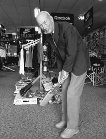 Photograph, Mr Alf Hunt with a cricket bat in Raitts Sports store in Upper Main Street previously, the Hunt family business