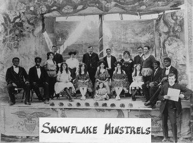 Photograph, Snowflake Concert Party Fred Berndt on right in front of stage with paper