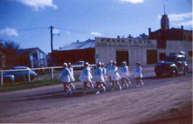 Photograph, Marching Girls in the Main Street Stawell with Mr Frank Floyds shop in the background c1960 -- Coloured