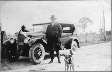Photograph, Man beside a tourer car parked on side of road c1920