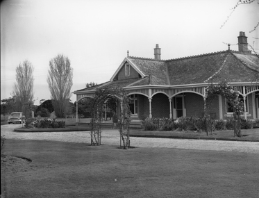 Photograph, "Swinton” Homestead in Glenorchy with two Rose archways on the lawn