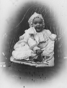 Photograph, Unknown baby seated in wicker chair -- Studio Portrait