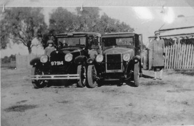 Photograph, Two sedan Cars parked in front of a residence