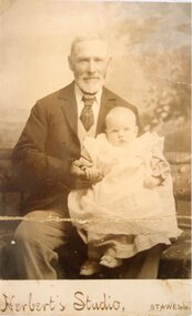 Photograph, Mr James McPhee a family friend nursing a baby Florence Hume who later became Mrs Harold Miller who lived in Stawell