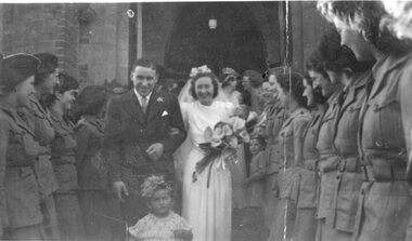 Photograph, Mr Reg Mason & Mrs Millie Mason nee Theos walking through a guard of honour formed by Aust Women's League Members