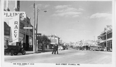 Photograph, McClure's Garage looking towards McCracken's and Commercial Bank c1940's -- Postcard. Two men in foreground. Rose Series Cards P12142 c1940's