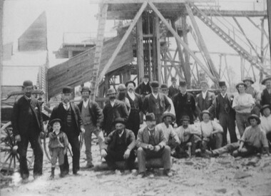 Photograph, Unknown mine with group of well dressed men in foreground and poppet head in background