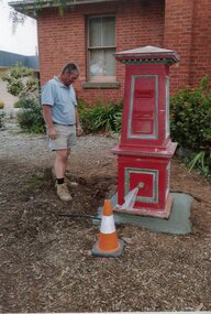 Photograph, Red Post Box previously located at Corner of Patrick St and Main Street 1874 being located at Historical Society Gardens by Paul Cuffe -- Coloured