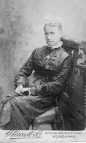 Photograph, Seated woman - dark Striped dress, necklace, chair cushioned, hair in bun, mop cap -- Studio Portrait