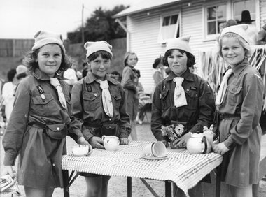 Photograph, Four brownies around table with tea