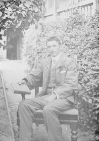 Photograph, Portrait of seated man in suite holding book