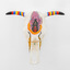 A 3D printed bull skull with horns painted in vibrant blue, red and  yellow stripes and black painted tips, and a redback spider painted on the centre of the skull.  A small crucifix is attached to the redback spider and beaded jewellery is looped through the eyes of the skull.