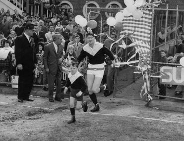 Photograph - Sunshine Football Team - Bob Henderson leading team onto South Melbourne Football Ground, [early 1960s]