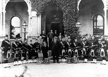 Photograph - Pipe band with McKay family members on steps of Ruppertswood